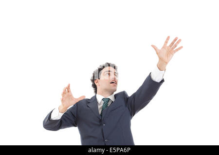 businessman with raised hands reaching for something with blank space, young man in suit reaching for something from above with  Stock Photo