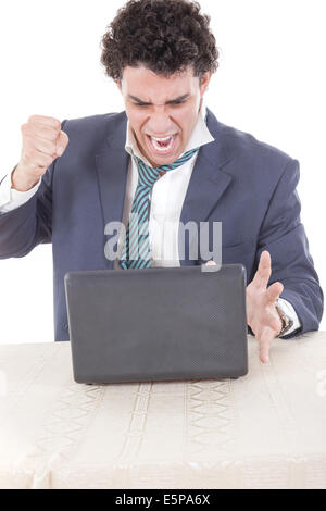 Photo of an angry caucasian business male frustrated with work sitting in front of laptop with his hand fist hitting laptop Stock Photo