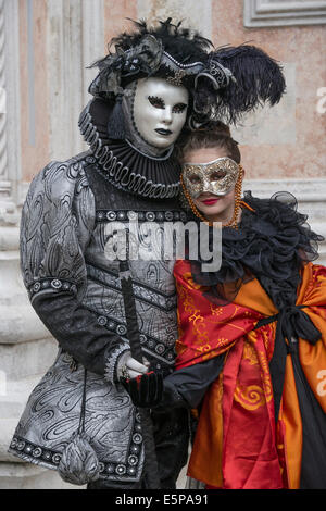 Elaborate black & silver costumed man with Spanish Senorita in front of San Zaccaria Church during Carnival in Venice. Stock Photo