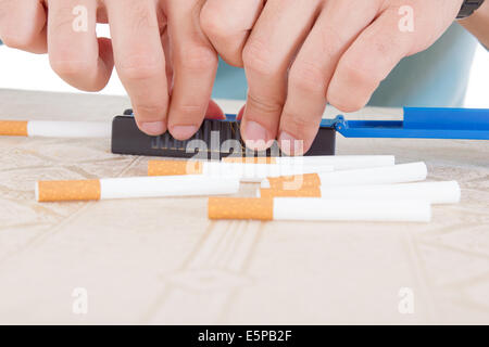 Hands making cigars using rollings and sticky paper with fresh tobacco for smoking Stock Photo