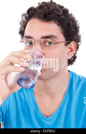 casual handsome man in blue t-shirt with glasses looking at camera while drinking healthy water from a glass Stock Photo