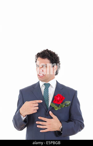 adult man in suit with disgust shows with his hand flower which is in his jacket pocket Stock Photo