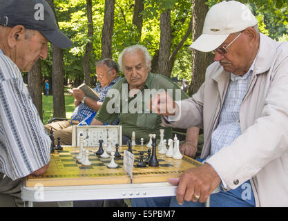 July 30, 2014 - Old men playing chess. Zheleznovodsk is a town in Stavropol Krai, Russia. Zheleznovodsk, along with Pyatigorsk, Yessentuki, Kislovodsk, and Mineralnye Vody, is a part of the Caucasus Mineral Waters, a renowned Russian spa resort. The town economy revolves around sanatoria, where dozens of thousands of people from all over Russia and former Soviet republics come year-around to vacation and rest, as well as prevent and treat numerous stomach, kidney, and liver diseases. Dozens of spas operate in Russia's Caucasus Mountains region, exploiting the mineral springs in the area, and Stock Photo