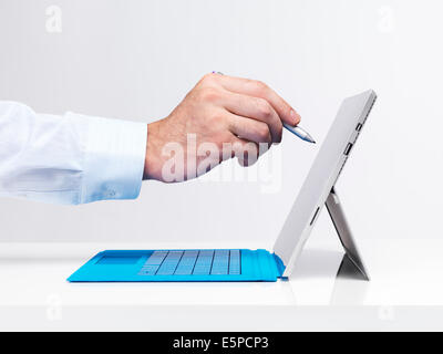 Closeup of a man's hand with a pen touching display of Microsoft Surface Pro 3 tablet computer isolated on white background Stock Photo