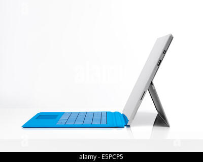 Microsoft Surface Pro 3 tablet computer with a blue keyboard side view isolated on white background Stock Photo