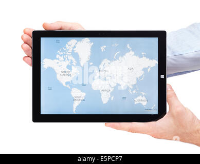 Person hands holding Microsoft Surface Pro 3 tablet computer with world map on its display isolated on white background Stock Photo