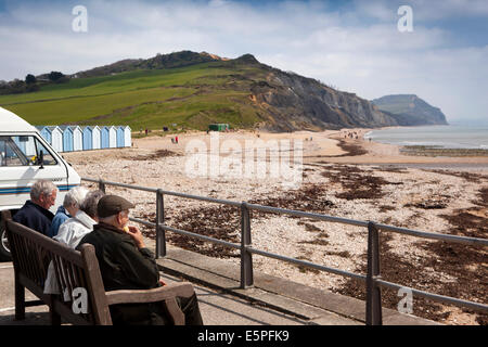 UK England, Dorset, Charmouth, visitors sat in sun overlooking the beach Stock Photo