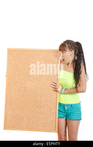 surprised and shocked pretty girl in shorts holding large wooden blank blackboard sing or frame, advertising banner sign Stock Photo