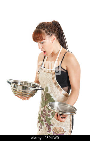 Surprised young woman standing in studio looking at empty cook pot when out of ingredients in grocery shopping concept Stock Photo