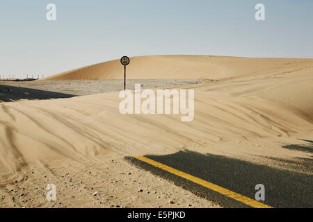 Sand dune blocks road in the Qatari desert, Qatar, Middle East Stock Photo