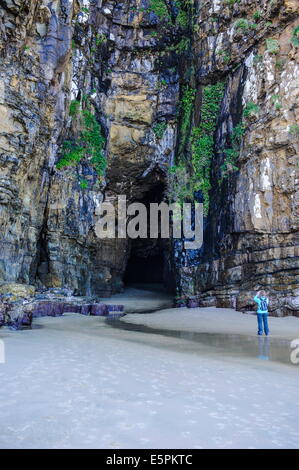Woman looking at the giant entrance of the Cathedral caves, The Catlins, South Island, New Zealand, Pacific Stock Photo