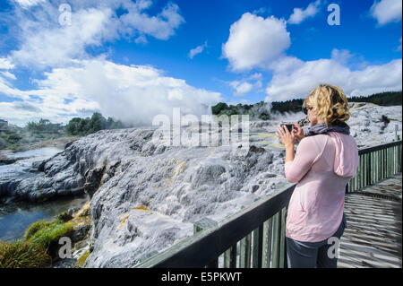 Woman looking at a Geysirfield  in the Te Puia Maori Cultural Center, Rotorura, North Island, New Zealand, Pacific Stock Photo