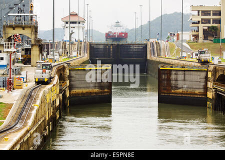 Lock gates closing at Miraflores with ship and mule trains, Panama Canal Stock Photo