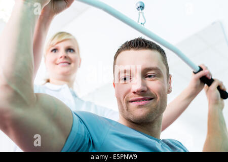 Patient at the physiotherapy doing physical exercises with therapist in sport rehabilitation Stock Photo