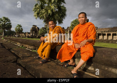 Two Buddhist monks on the outside of the Temple of Angkor Wat. Angkor Wat, in its beauty and state of preservation, is unrivaled Stock Photo