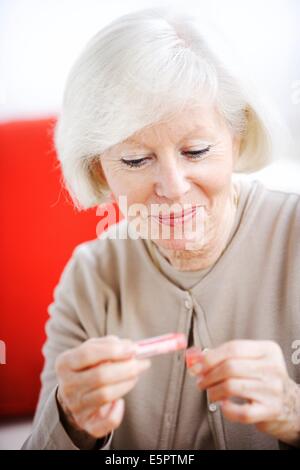 Senior woman taking homeopathic medicine. Stock Photo
