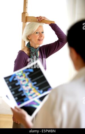 Doctor measuring the height of a female patient during medical consultation. Stock Photo