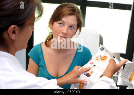 Teenage girl receiving Nutrition Education consultation with dietician. Stock Photo