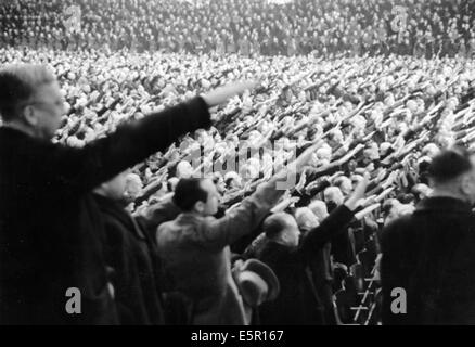 A large group of people listen to the speech by Propaganda Minister Joseph Goebbels, who called for 'total war' at the Sportpalast in Berlin, Germany, 18 February 1943. The original Nazi propaganda text on the back of the picture: 'Special event by the NSDAP. Gau Berlin in the Sportspalast with a speech by the Gauleiter of Berlin, Reich Minister Dr. Goebbels. Our picture shows thousands of spectators showing their never-ending consent as Reich Minister Dr. Goebbels asked the listeners, a group that embodied the entire German people from all ranks, for approval of the measures related to total  Stock Photo