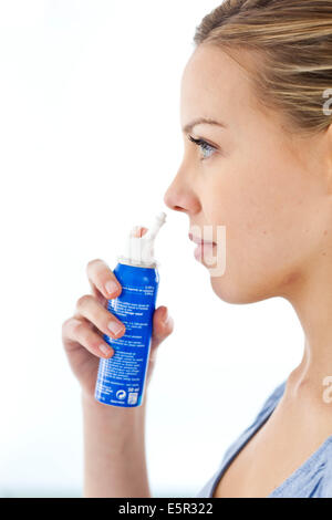 Woman using a sterile sea water spray. Stock Photo