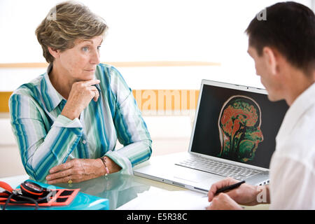 Doctor discussing brain MRI (Magnetic Resonance Imaging) with a patient. Stock Photo