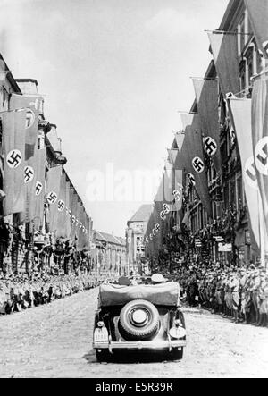 People cheer at the arrival of Hitler's motorcade on Wilhelmplatz in front of a crowd of cheering people as Hitler returns from his Felsennest headquarters after the Armistice of Compiegne was signed that ended the western campaign in France in Berlin, Germany, 06 July 1940. 'The capital of the Reich received the victorious commander with cherring. On Saturday afternoon, the Reichs capital was marked by the return of the leader, the victor of the largest and most brilliant battle in German history. The streets through which the Fuhrer drove were filled with hundreds of thousands of people who  Stock Photo