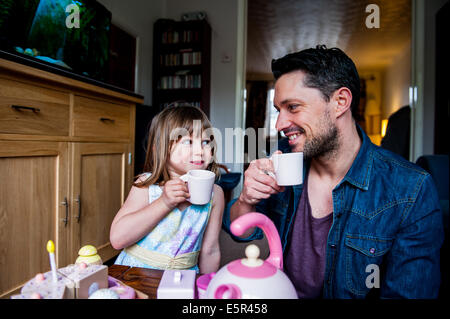 dad and daughter drinking tea and having fun Stock Photo
