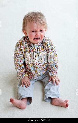 Crying 13-month-old baby girl. Stock Photo