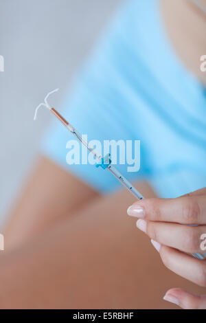 Woman holding intra-Uterine contraceptive Device. Stock Photo