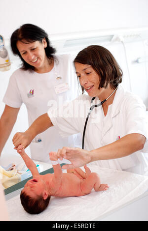 Pediatrician examining a newborn baby (grasping), Obstetrics and gynaecology department, Saintonges hospital, Saintes, France. Stock Photo