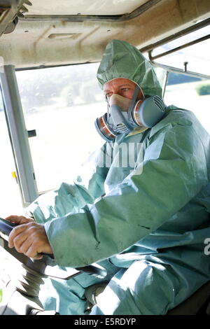 Farmer wearing protective suit and mask when applying chemicals on fields, This farmer uses sustainable farming practises in Stock Photo