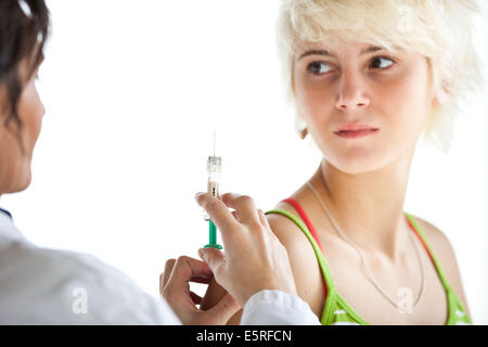 Teenage girl receiving vaccination (Gardasil vaccine) against certain types of the human papillomavirus (HPV) responsible for Stock Photo
