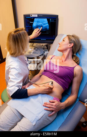 Woman undergoing pelvic ultrasound scan, Limoges hospital, France. Stock Photo