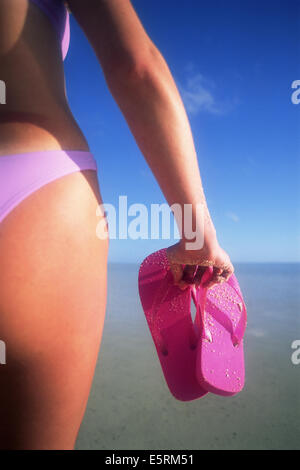 Woman with sandals on beach Stock Photo