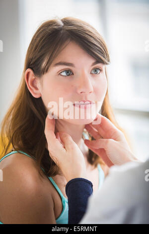 General practitioner palpating the lymphatic glands of a patient during medical consultation. Stock Photo