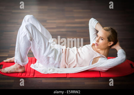 Woman practicing stretching exercises to relieve back pain. Stock Photo