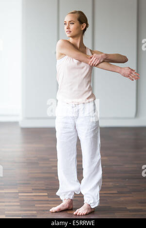 Woman practicing stretching exercises to relieve back pain. Stock Photo