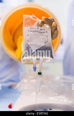 A compounder is preparing chemotherapy treatments under glove box. Limoges hospital pharmacy. Stock Photo