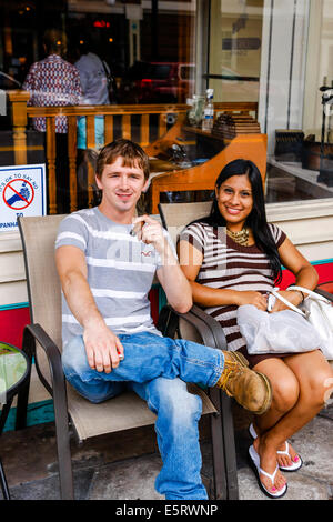 Young white American man with his hispanic girlfriend sits smoking a cigar in Ybor City Fl Stock Photo