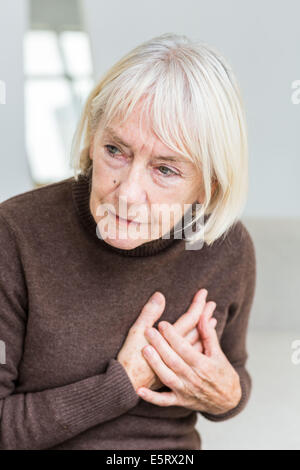 Senior woman clutching her painful chest. Stock Photo