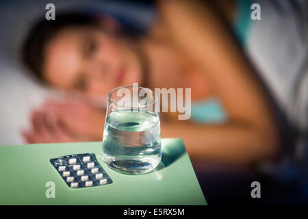 Woman taking medication in bed. Stock Photo