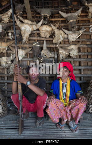 Htang Peh, a Chin hunter, and his wife Naing Laing in  front of the exterior wall of their house in Krai Do (Kyar Hto) village, Stock Photo