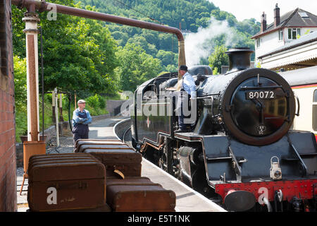 A steam locomotive taking on water at Llangollen station, Denbighshire, Wales. Stock Photo