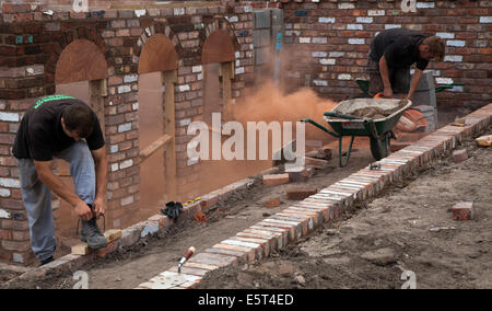 Hard landscaping & brick cutting for paths, driveways, garden walls in Southport, Merseyside, UK.  5th August, 2014.   Angle grinders being used by bricklayers for cutting paving bricks. Construction site as Flower Show preparations get underway in Victoria Park Southport showgrounds for the UK’s largest independent flower show. Stock Photo