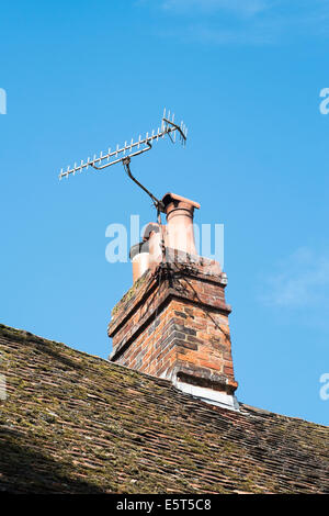 UK television reception ariel mounted on chimney against blue sky Stock Photo