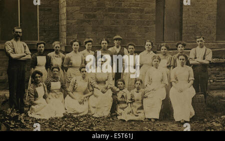 1906 photograph 17 mill-girls, in white aprons, with three men overseers, Woodvale Cotton Mill, Thornhills Briggs, Brighouse, UK Stock Photo