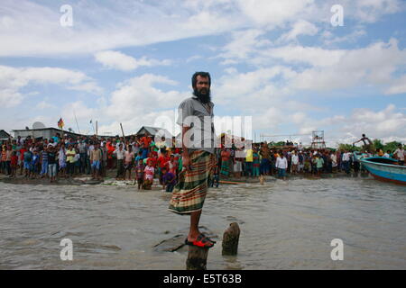 Mawa, Bangladesh, Bangladesh. 4th Aug, 2014. People and relatives stands in the bank of river Padma. The Pinak-6, a passenger vessel sank in the middle of the river Padma on its way to Mawa from Kawrakandi terminal. The boat capsized since the river was rough due to the stormy weather. At least 250 people were in the capsized boat. Local people rescued nearly 45 passengers from the river and many other are still missing. Stormy weather and strong current hamper the rescue operation. © Suvra Kanti Das/ZUMA Wire/ZUMAPRESS.com/Alamy Live News Stock Photo
