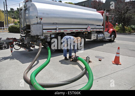 woman driver of gasoline tanker delivers gas to service station in Marin County California Stock Photo