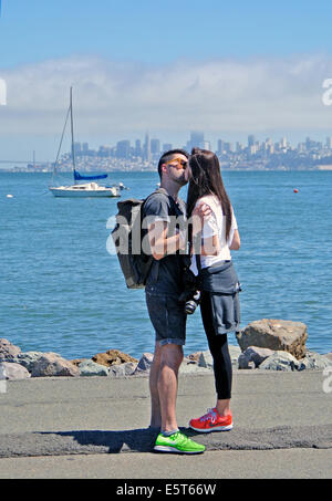 an Asian couple kiss and embrace in Sausalito on San Francisco Bay Stock Photo