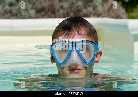 Teenager boy wearing diving mask or goggles in swimming pool. Stock Photo